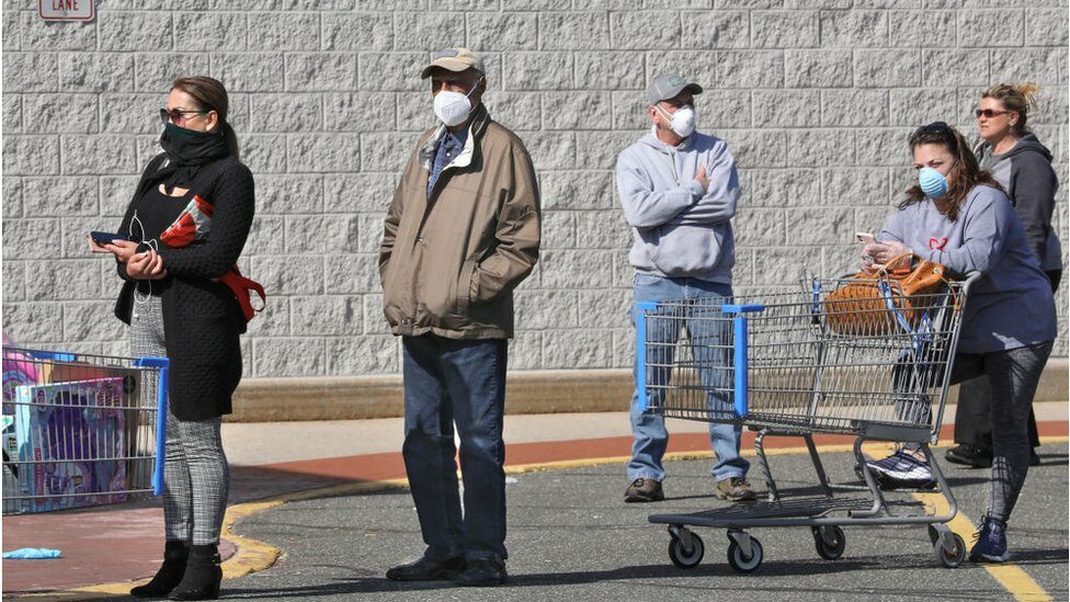 Shoppers in a line with masks on