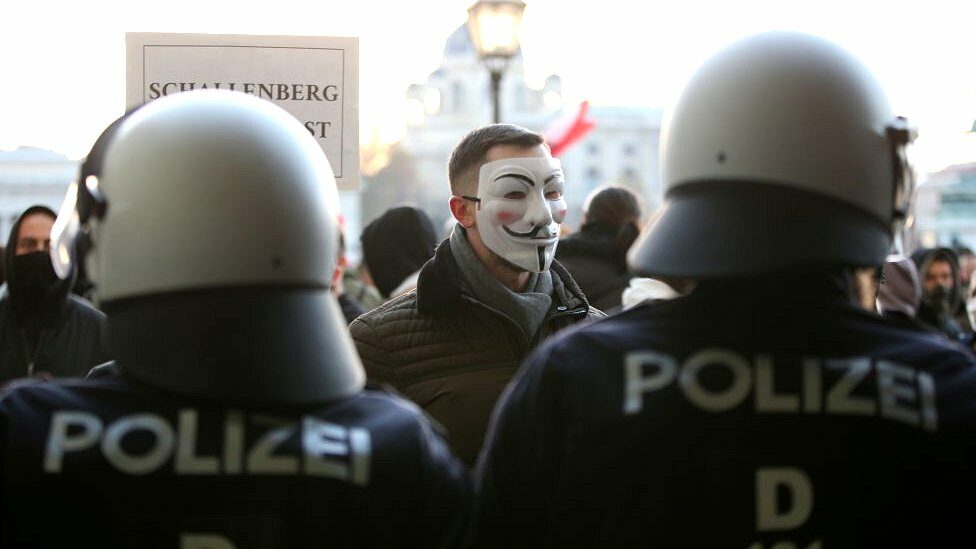 Man in anonymous mask surrounded by police in Austria